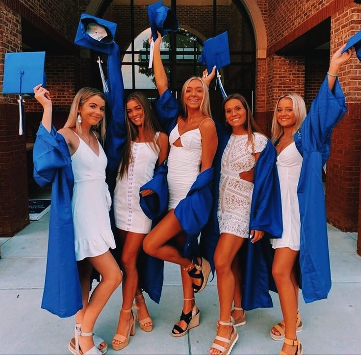 four women in graduation gowns posing for the camera