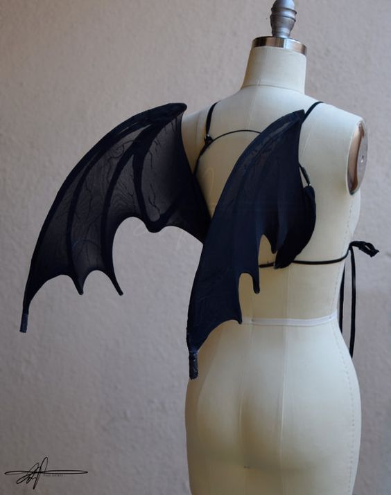 a white mannequin with black bat wings on it