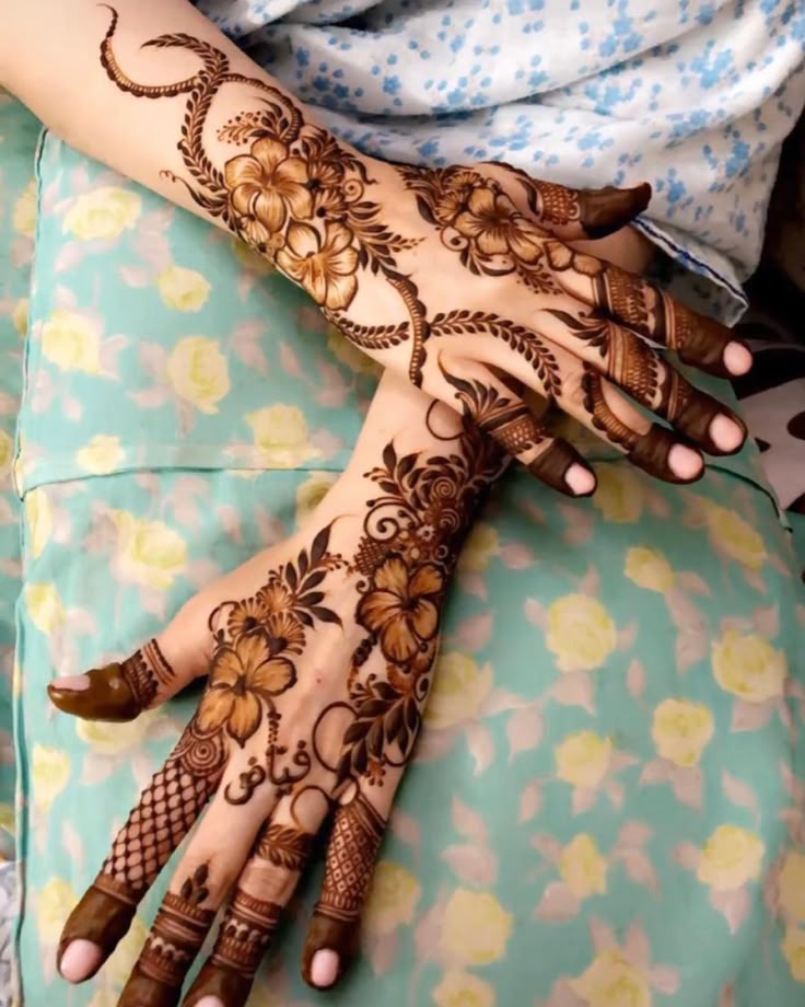 a woman's hands with hennap on her hand and flowers painted on it