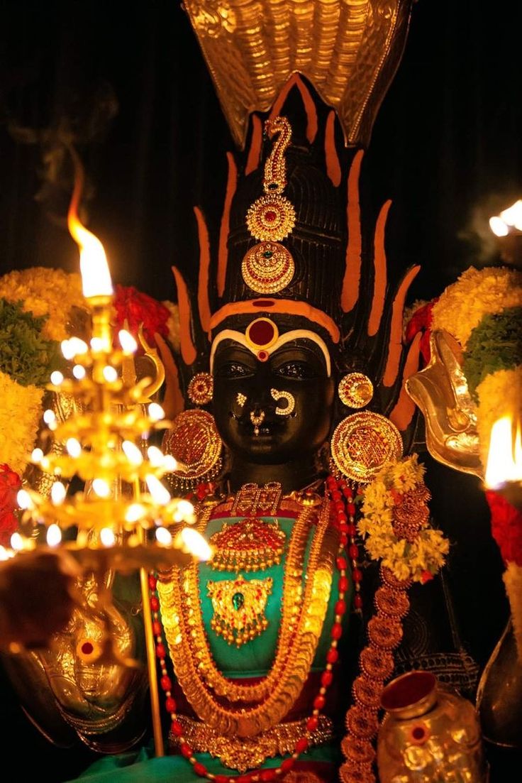 an idol is shown with candles in front of it