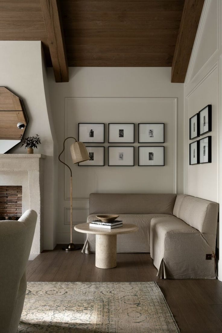 a living room filled with furniture and pictures on the wall above it's fireplace