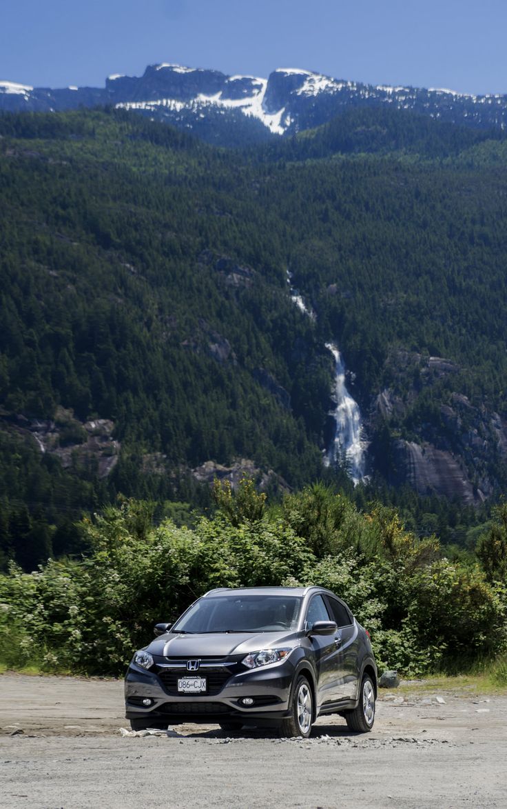 a car parked on the side of a dirt road in front of a mountain range