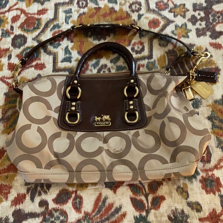 This Bag Is In Excellent New Condition, Never Used. It Has A Removable Shoulder Strap And Two Interior Pockets. Approximate Measurements Are L-12in, H-9in, D-5in Beige Coach Bag With Detachable Strap, Beige Shoulder Bag With Branded Hardware, Cream Satchel With Branded Hardware For Travel, Beige Travel Bag With Branded Hardware, Beige Crossbody Satchel With Branded Hardware, Beige Travel Shoulder Bag With Branded Hardware, Beige Double Handle Satchel With Branded Hardware, Cream Shoulder Bag With Branded Hardware For Travel, Beige Shoulder Bag With Branded Hardware For Travel