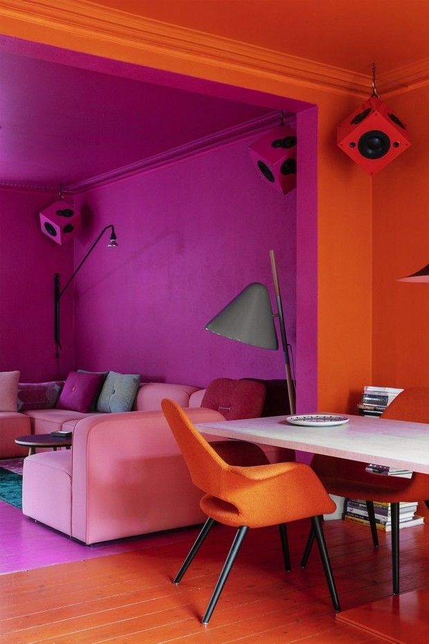 an orange and pink living room with modern furniture