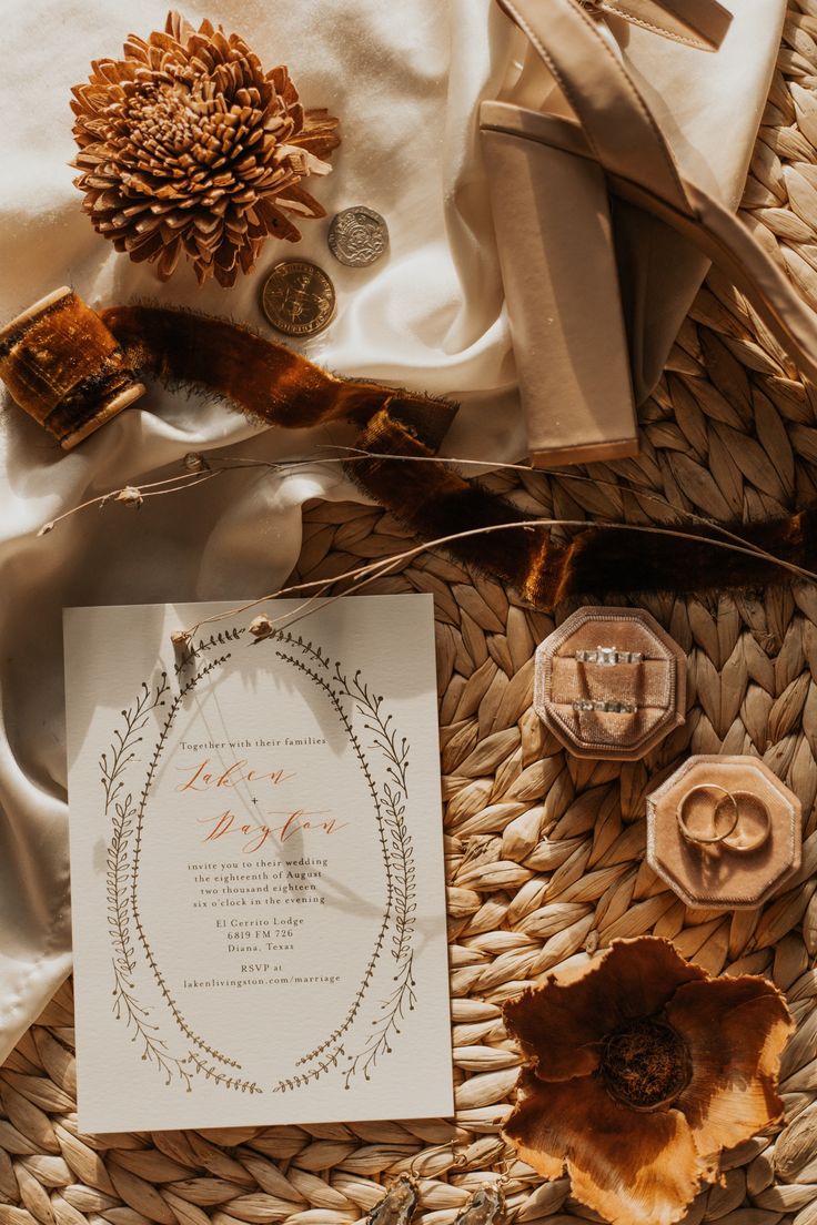 the wedding stationery is laid out on top of some wicker and other items