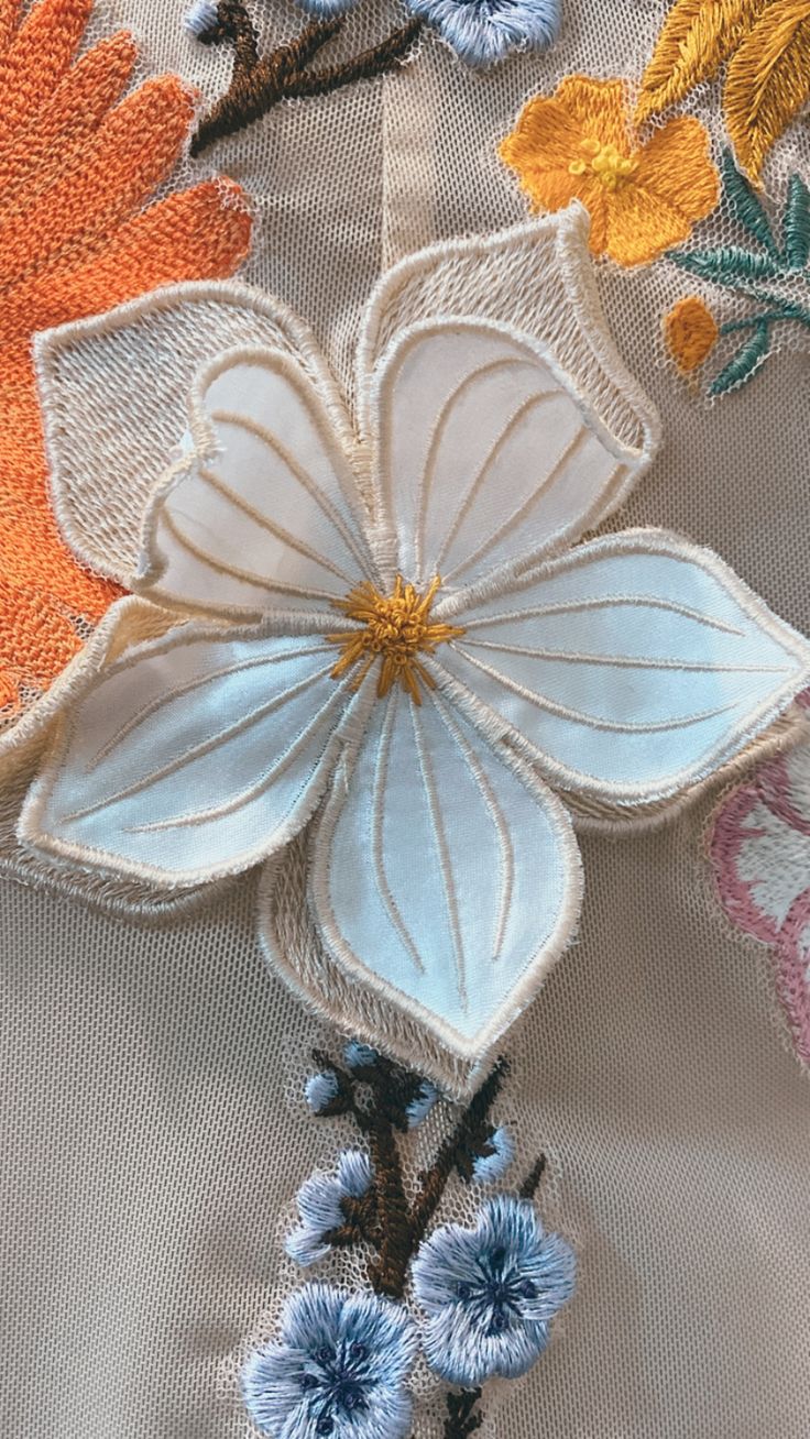 an embroidered flower is shown on the fabric