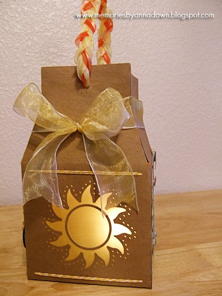 a brown box with a gold sun on it and two candy sticks sticking out of the top