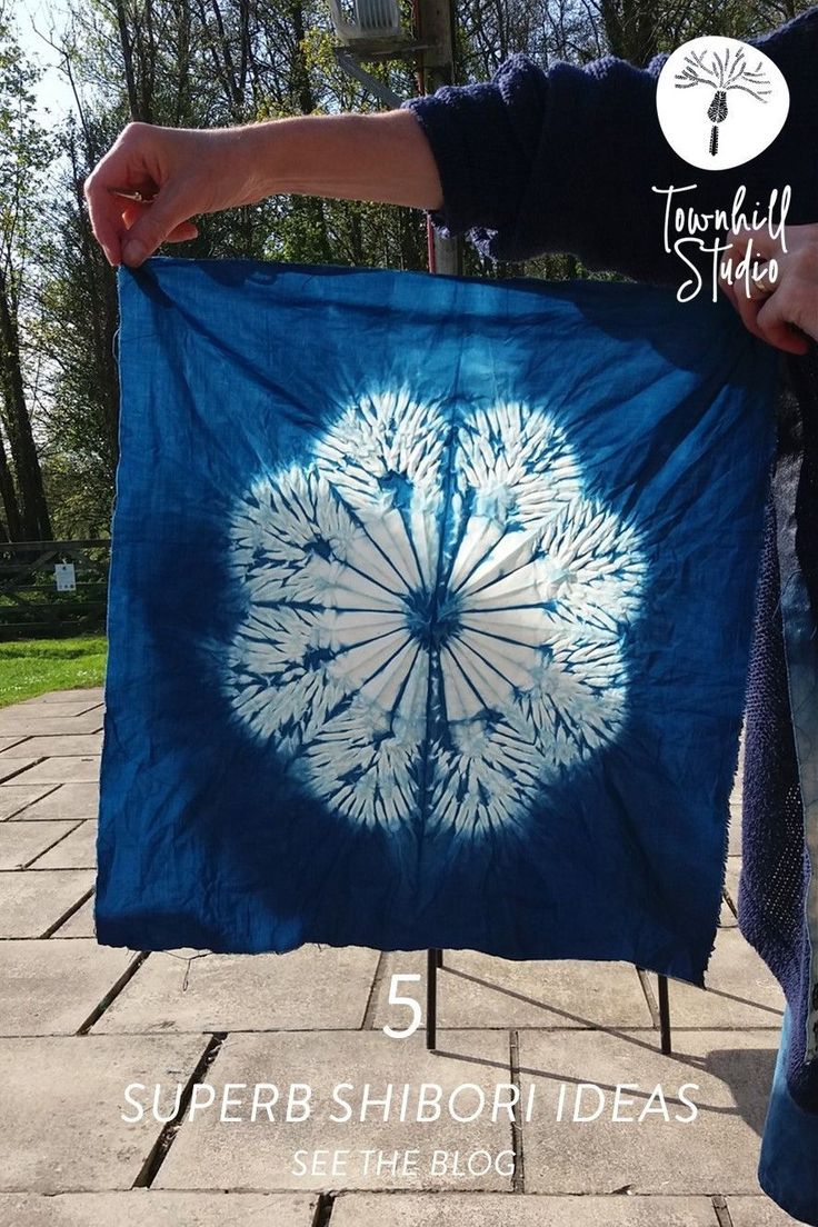 a person holding up a blue and white tie - dyed cloth