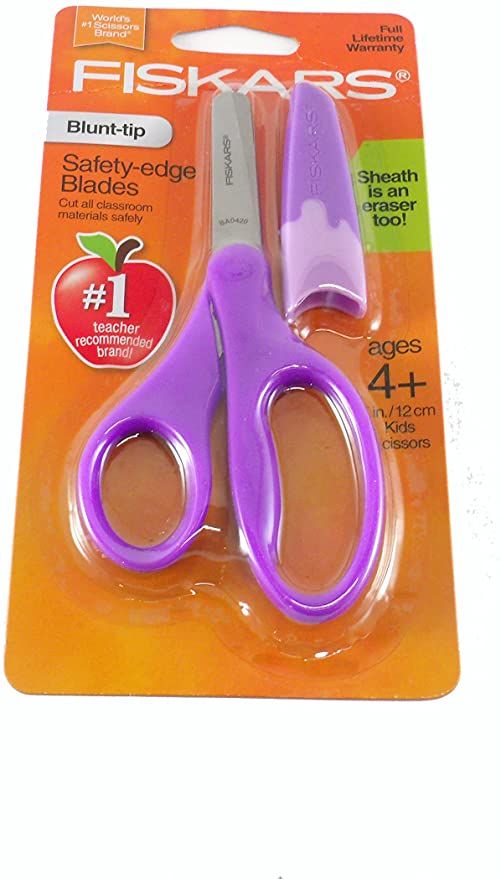 two pairs of scissors sitting on top of each other in front of an orange package