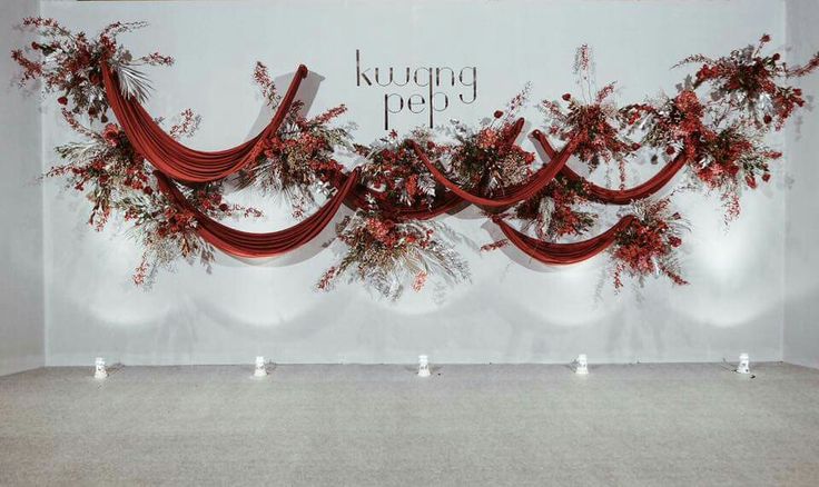 a room with red curtains and flowers on the wall