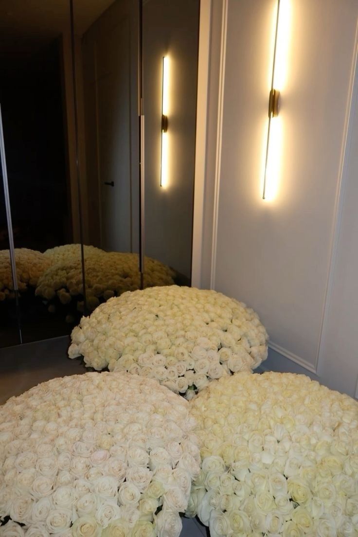 a bunch of white flowers sitting on top of a floor in front of a mirror