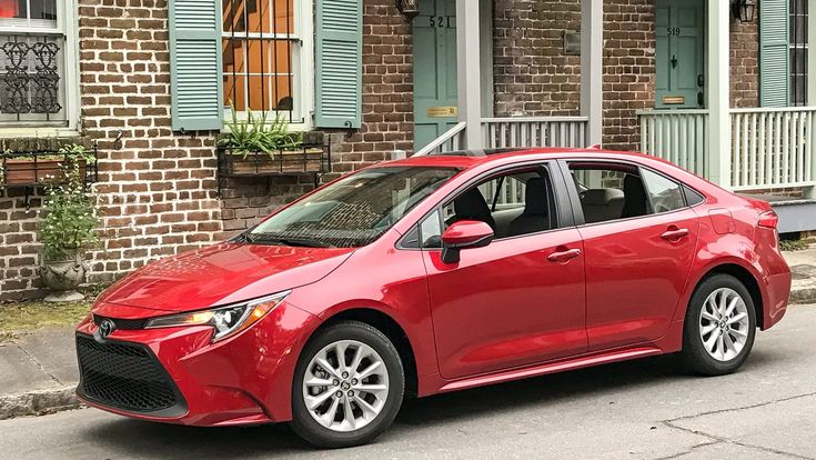 a red car parked in front of a brick building