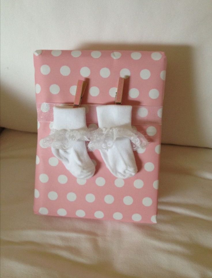 two baby's socks are hanging on a pink and white polka dot wall hanger