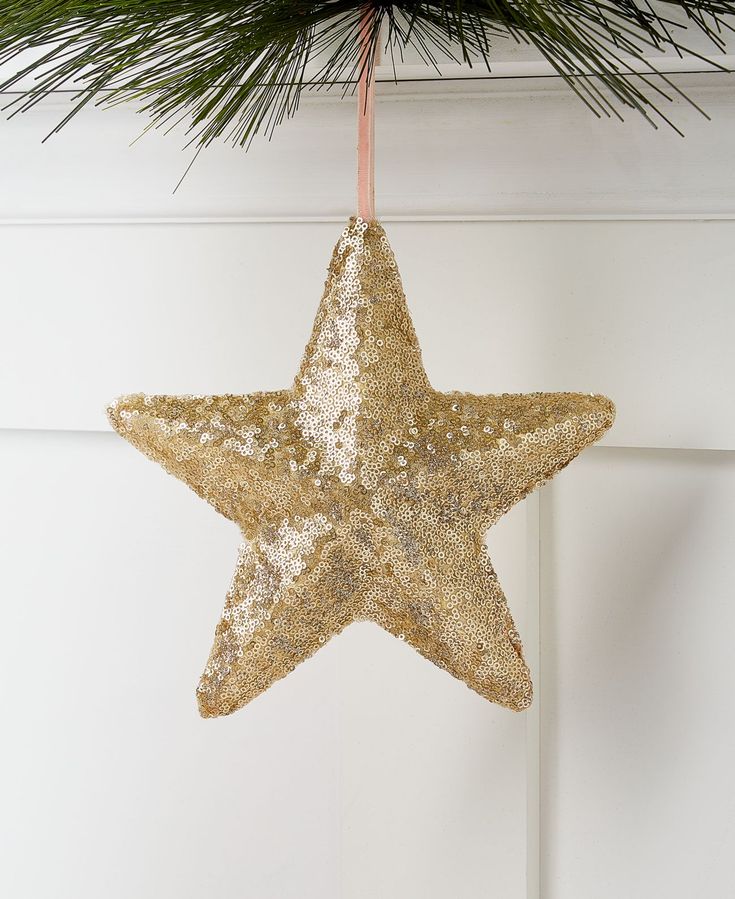 a gold star ornament hanging from a christmas tree