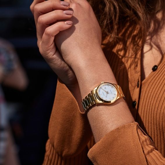 This classic Eco-Drive Sport women's watch from Citizen showcases shimmering diamond indexes, a date window at 3 o'clock and high-contrast white mother-of-pearl dial with luminescent hands for essential information at a glance. A sapphire crystal tops the 33mm yellow gold stainless steel case while a fold-over clasp secures the yellow gold steel bracelet. The women's watch features an Eco-Drive movement powered by any light, so it never needs a battery. Yellow Watches, Womens Designer Watches, Eco Drive Watches, Citizen Eco, Peoples Jewellers, Eco Drive, Bridal Designs, Women's Watch, Stainless Steel Watch