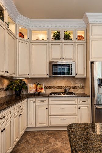 a kitchen with white cabinets and granite counter tops