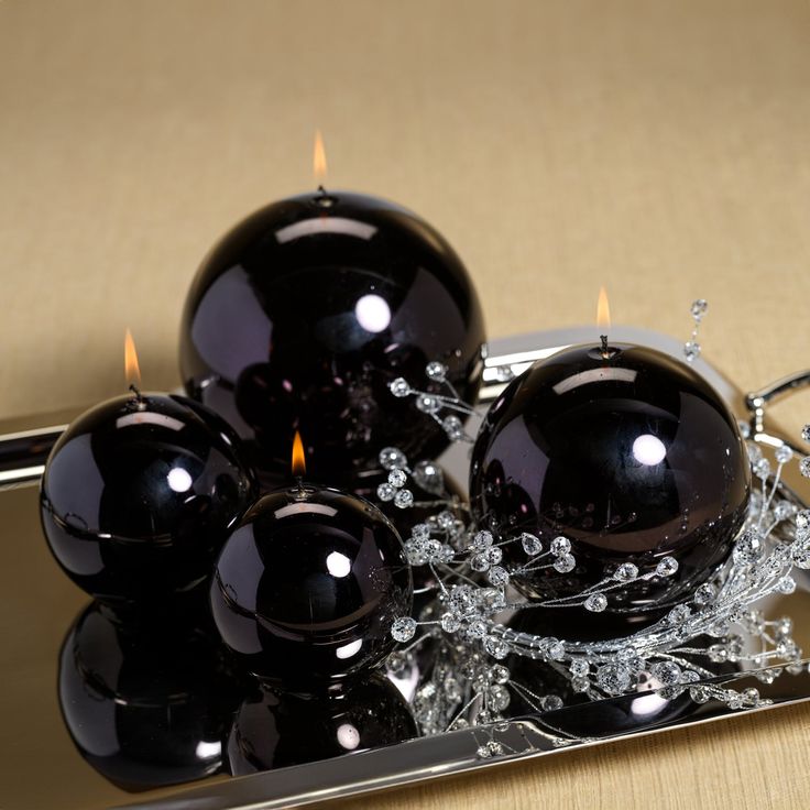 some black candles are on a silver tray