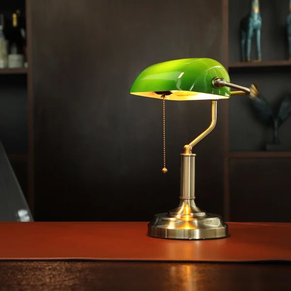 a green lamp sitting on top of a wooden table