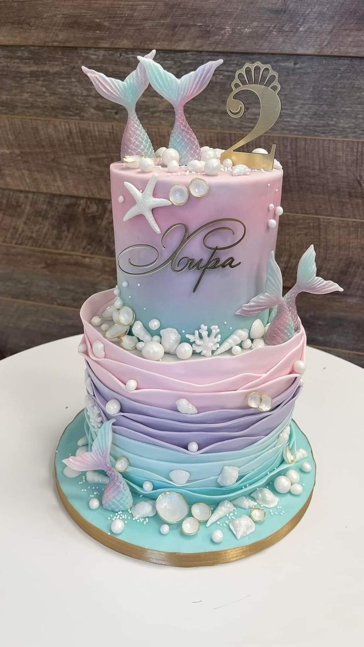 a three tiered cake is decorated with pastel colors