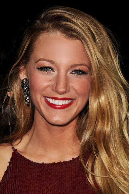 a woman with long blonde hair smiling at the camera