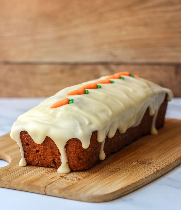 a carrot cake with icing on a cutting board