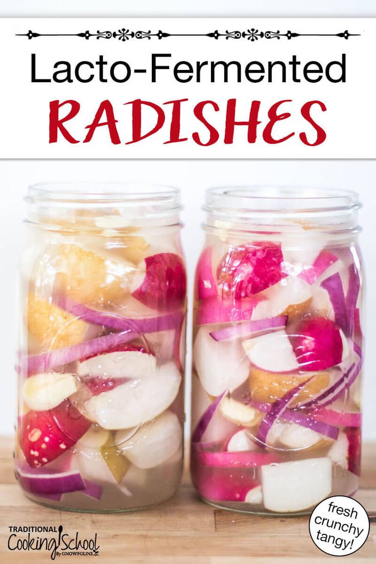 two jars filled with food sitting on top of a wooden table next to each other