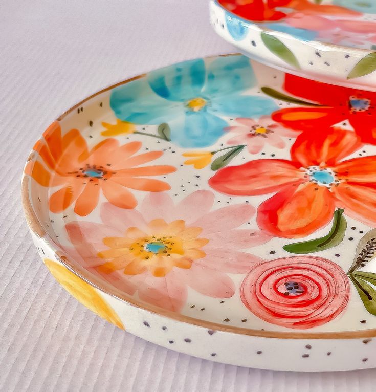 two colorful plates with flowers painted on them