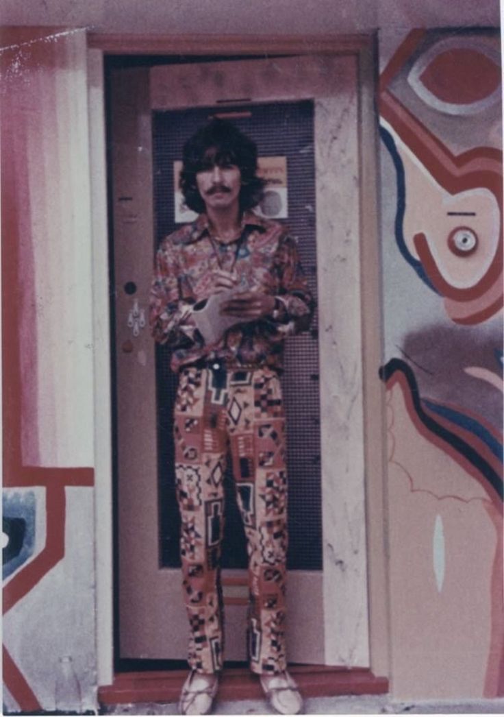 a man standing in front of a door with his hands on his hipster pants