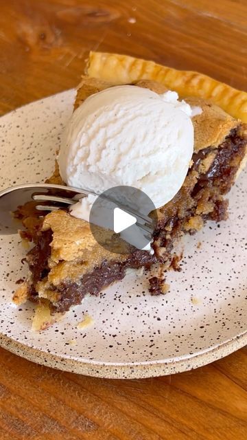 a piece of pie with ice cream on top is sitting on a plate and has a fork in it