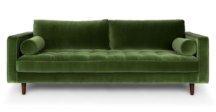 a green couch sitting on top of a white floor