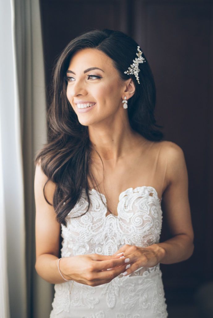 a woman in a wedding dress smiles as she holds her hands together and looks off to the side