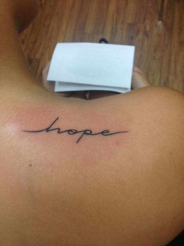 a woman's back with the word hope tattooed on it