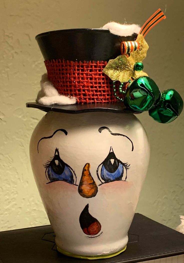 a ceramic pot with a face painted on it's side and a top hat