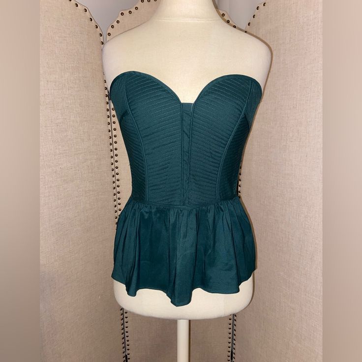 Nwt, Size M. Emerald Green In Color With A Zipper Back And Additional Smocking For A Tailored Fit. Such A Staple Piece For Upcoming Thanksgiving Or Christmas Holiday Parties. Fitted Green Top For Date Night, Spring Strapless Top With Fitted Bodice, Chic Fitted Ruched Peplum Top, Ruffled Tops With Fitted Bodice For Parties, Ruffled Fitted Bodice Tops For Party, Fitted Tops With Smocked Back For Party, Fitted Tops With Ruffles And Sweetheart Neckline, Fitted Ruffle Tops With Sweetheart Neckline, Fitted Ruffle Top With Sweetheart Neckline