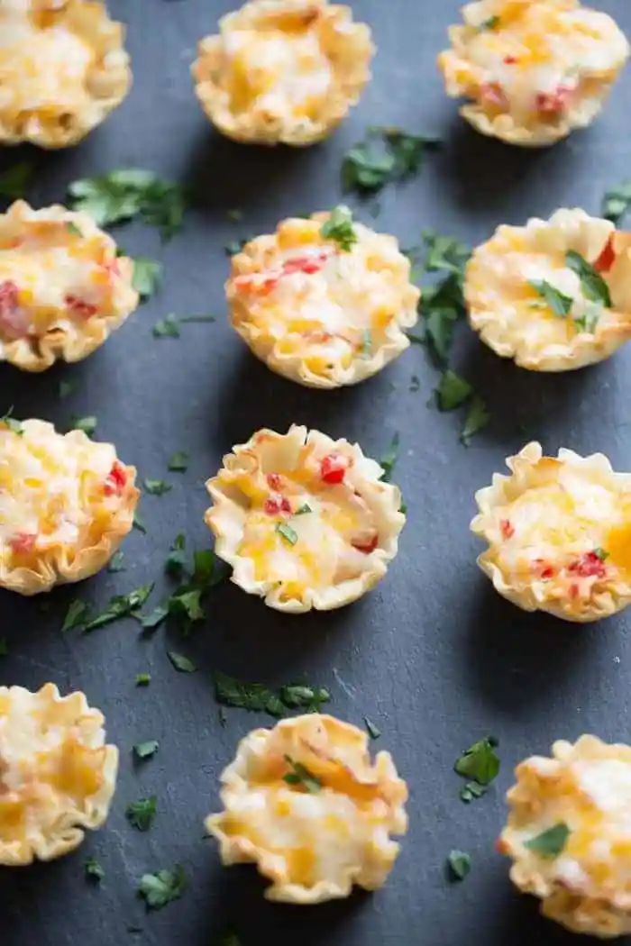 small appetizers with cheese and herbs on a baking sheet, ready to be eaten