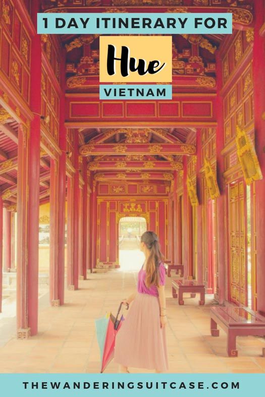 a woman with an umbrella standing in the middle of a hallway that has red pillars and arches