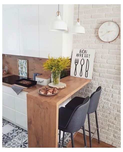 a kitchen with white brick walls and black chairs