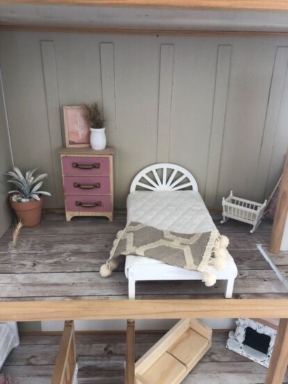 a dollhouse bedroom with a bed and dresser