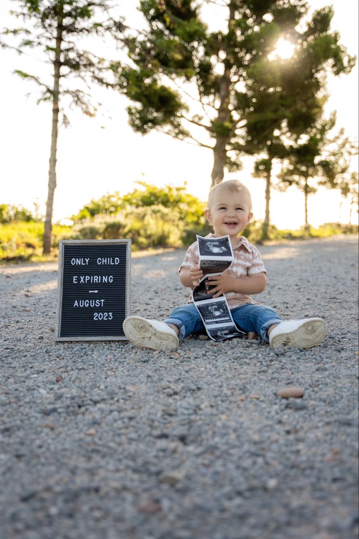 a small child sitting on the ground with some books