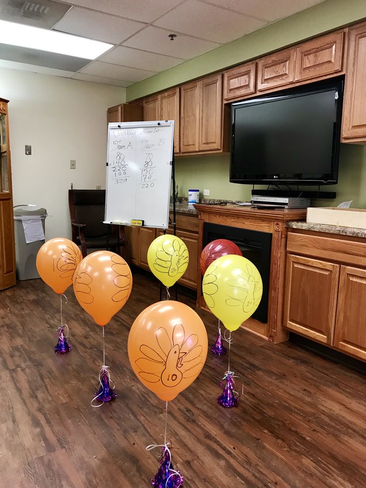 balloons with faces drawn on them are lined up in the middle of an office space