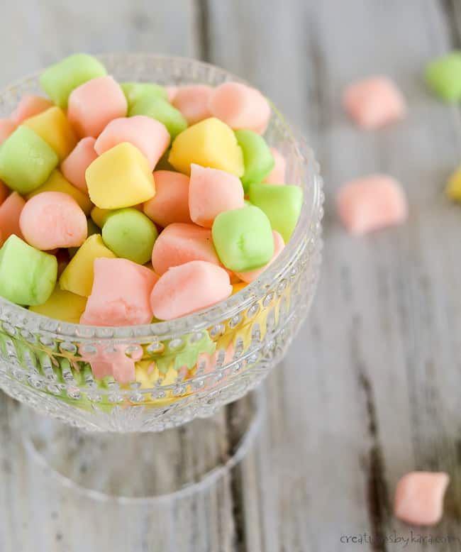 a glass bowl filled with marshmallows on top of a wooden table