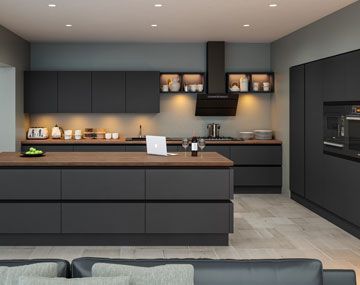 a modern kitchen is shown with black cabinets and counter tops, as well as an island in the middle