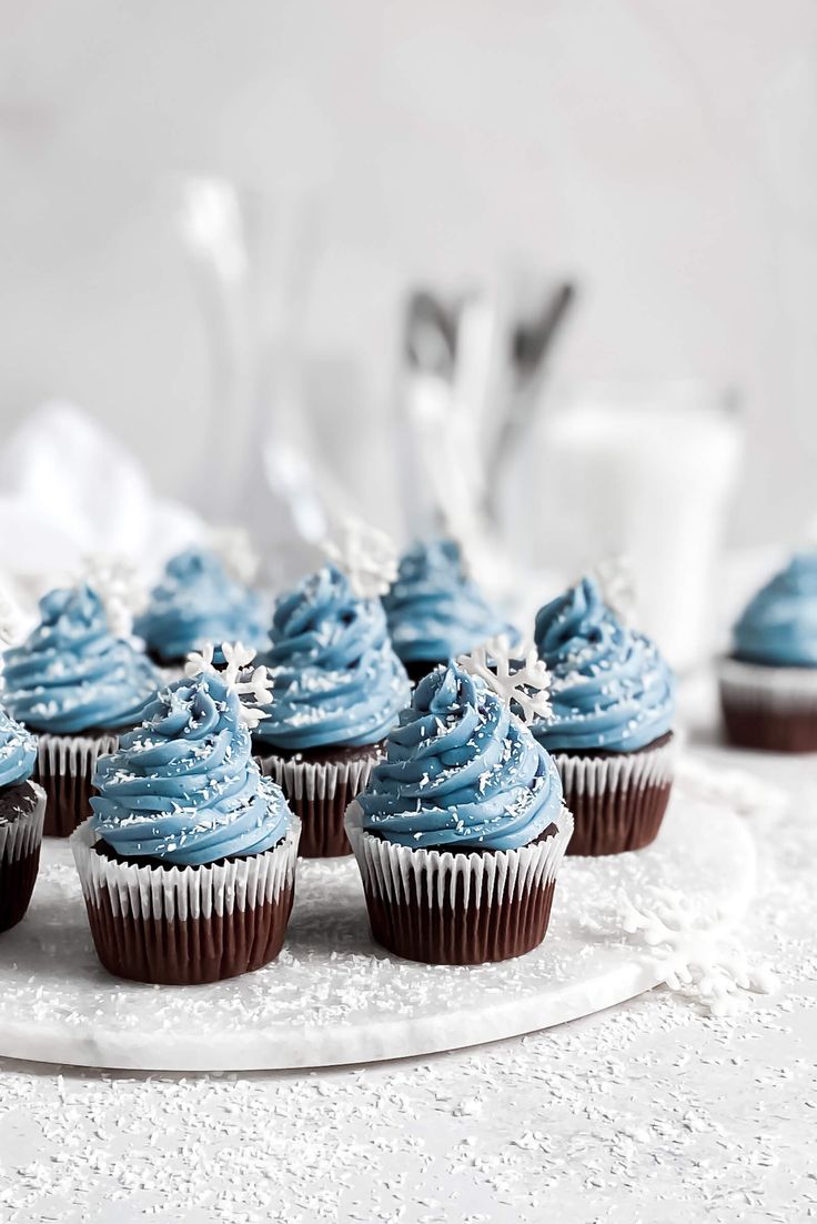 cupcakes with blue frosting on a white plate