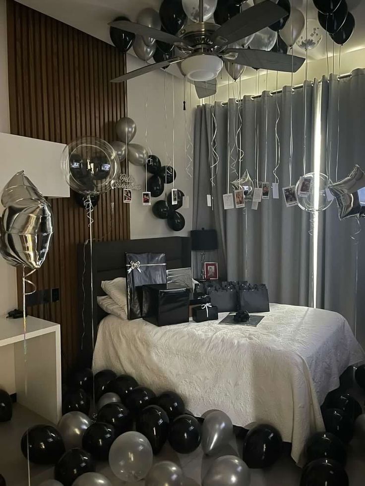 a bedroom decorated with black and silver balloons