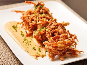 a white plate topped with fried food on top of a table