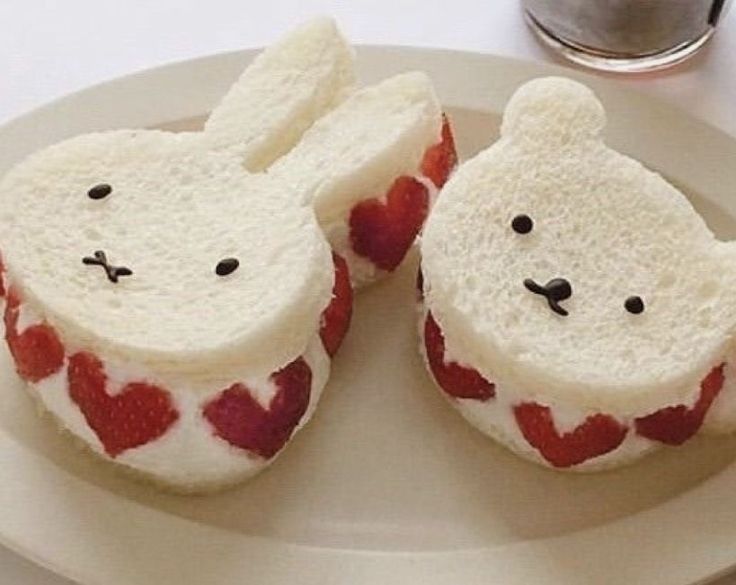 two slices of bread shaped like buns with hearts on them sitting on a plate