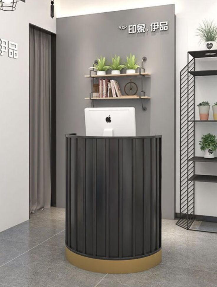 an office with a laptop on the desk and shelves above it that have bookshelves