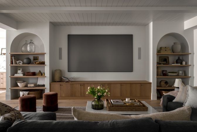 a living room filled with furniture and a flat screen tv mounted to the side of a wall