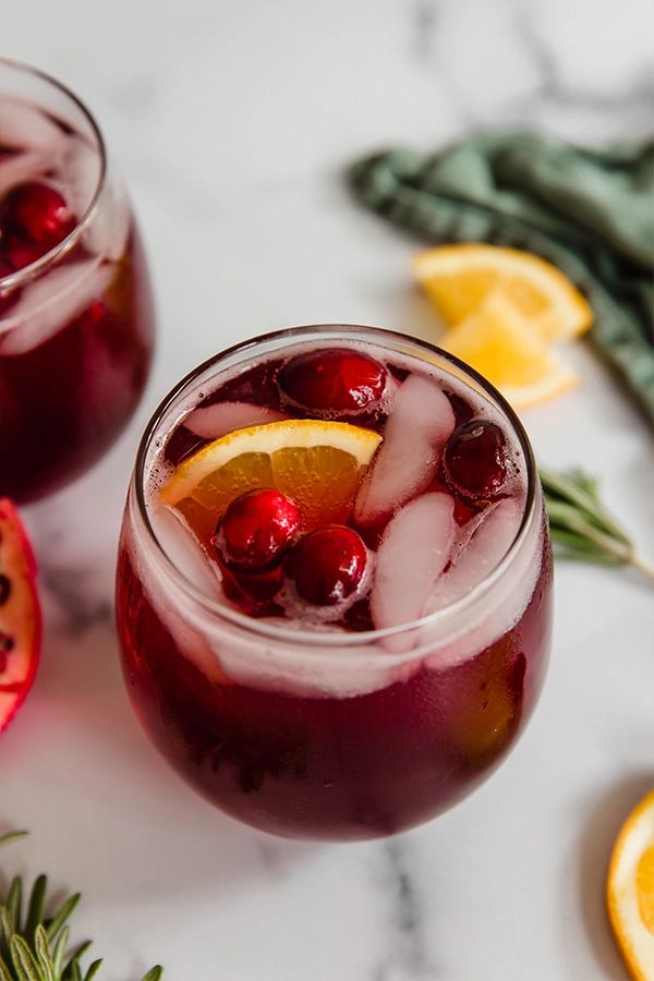 a red drink with ice and lime garnish