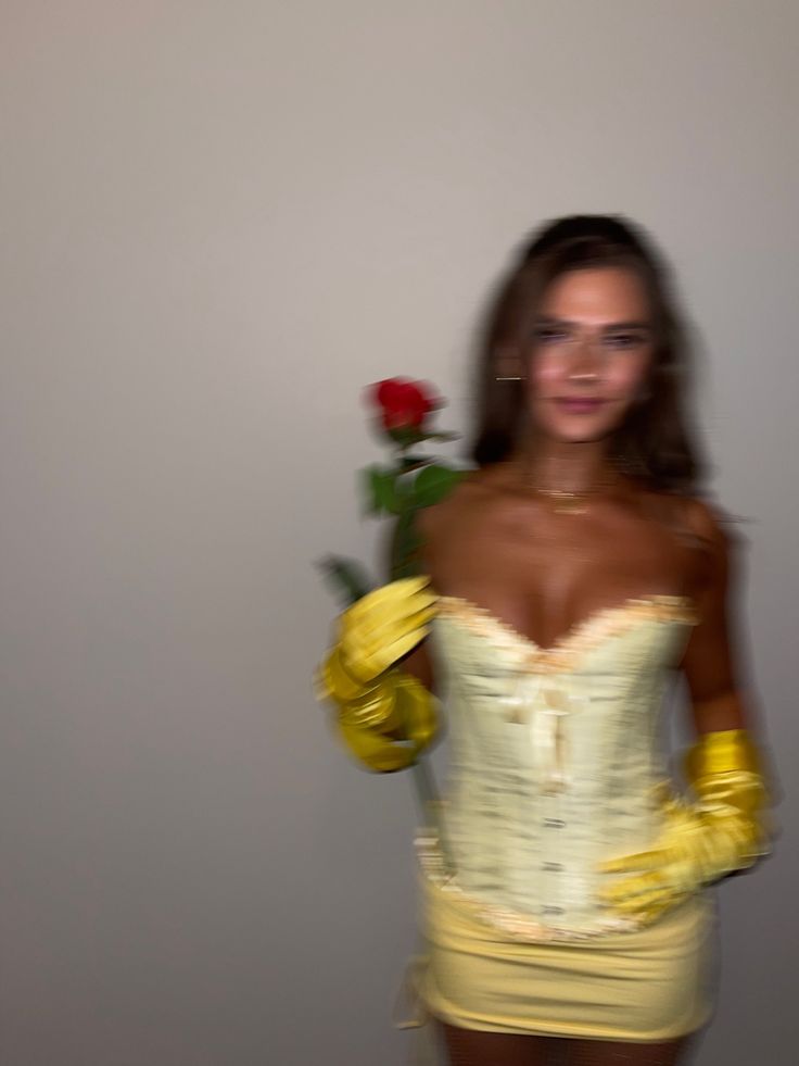 a woman in a yellow dress holding a red rose and gloved gloves on her arm